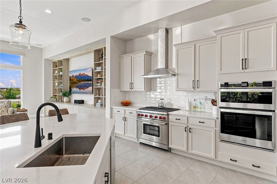 High ceilings and a generous island anchor this gourmet kitchen space which features Wolf range, built in premium finishes.
