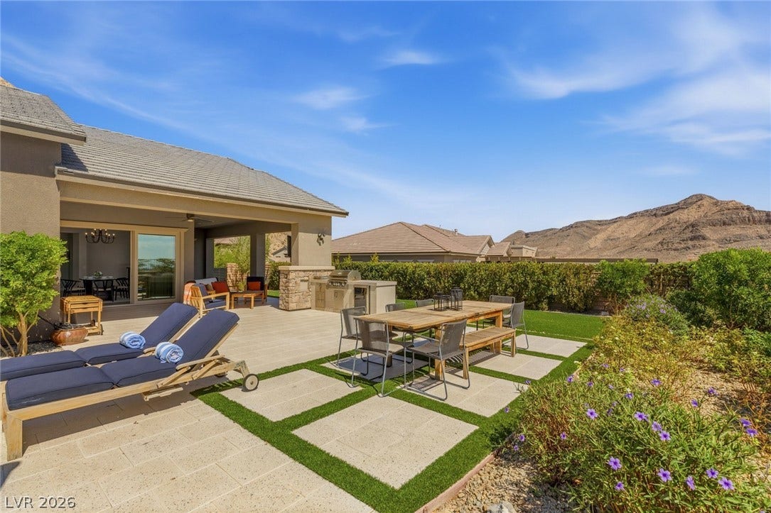 An expansive patio offers a built-in outdoor kitchen alongside sweeping desert mountain views.