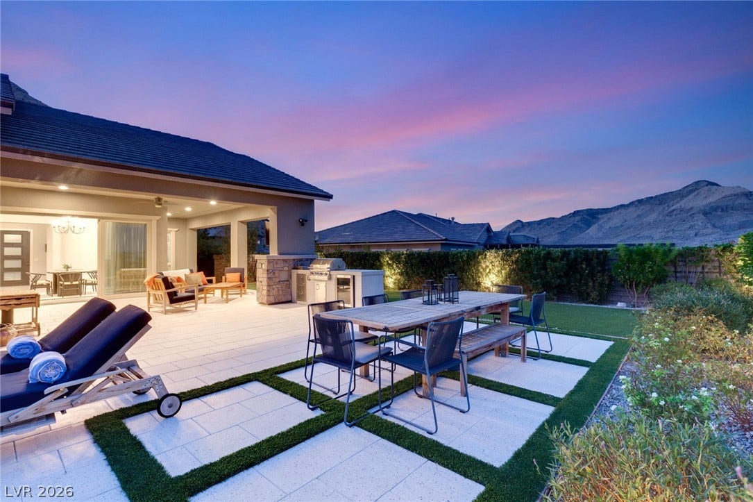 An expansive patio offers seamless outdoor dining against a majestic mountain backdrop.