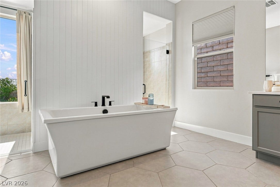 An oversized soaking tub anchor this refined, spa like primary bathroom.