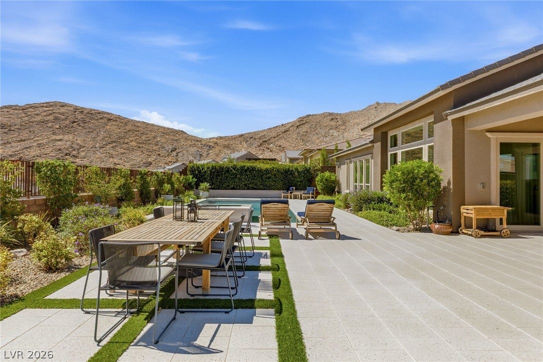 A spacious patio opens to an inviting swimming pool set against scenic desert hills.