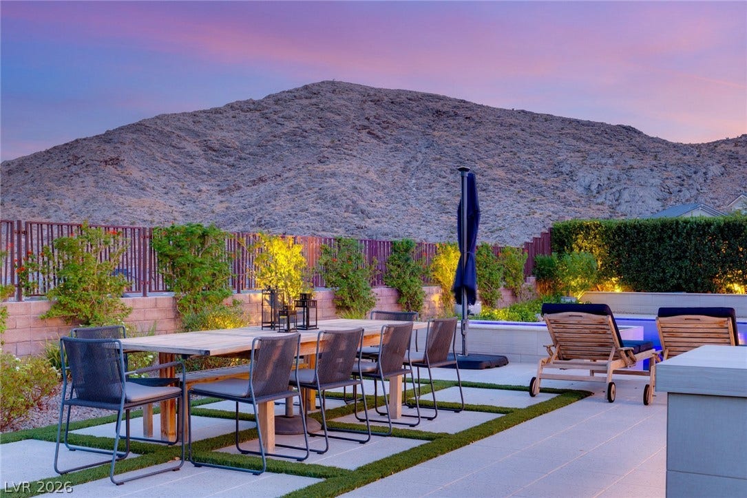 A spacious patio overlooks dramatic mountain views beneath a twilight sky.