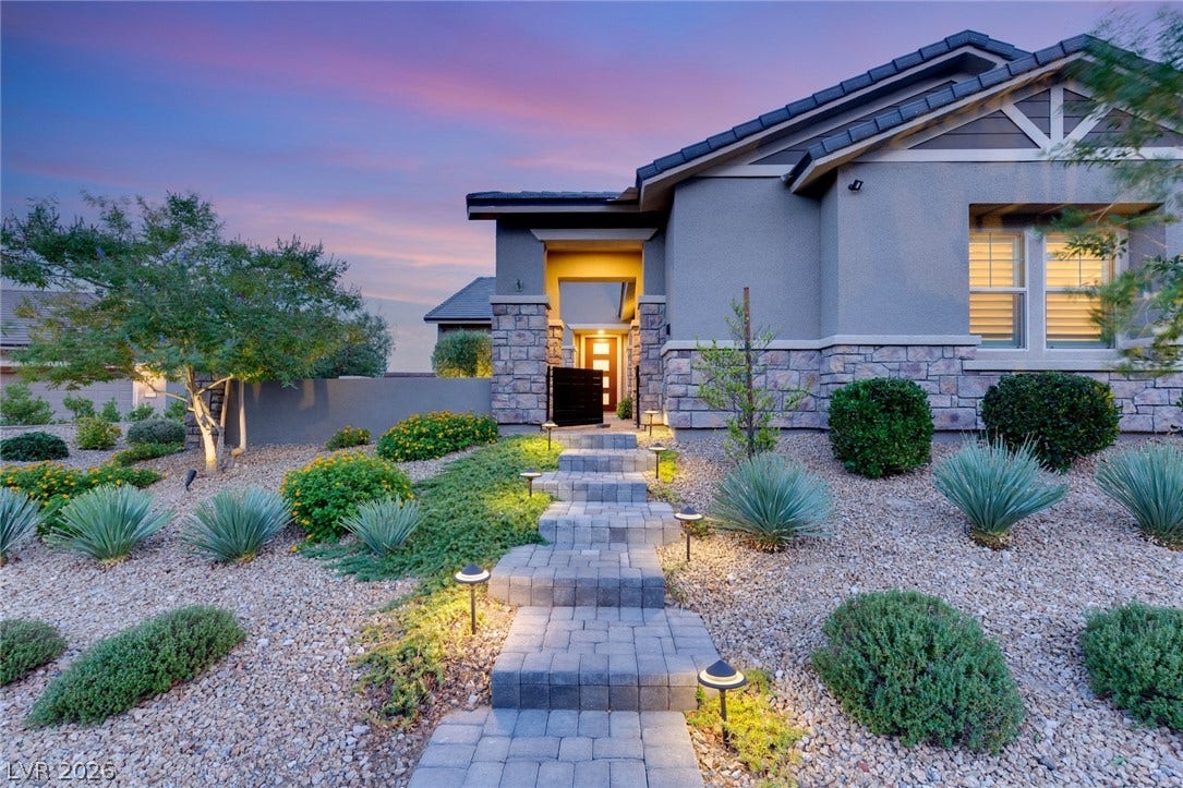 A stone-accented exterior is complemented by a lit walkway. Beautiful curb appeal.