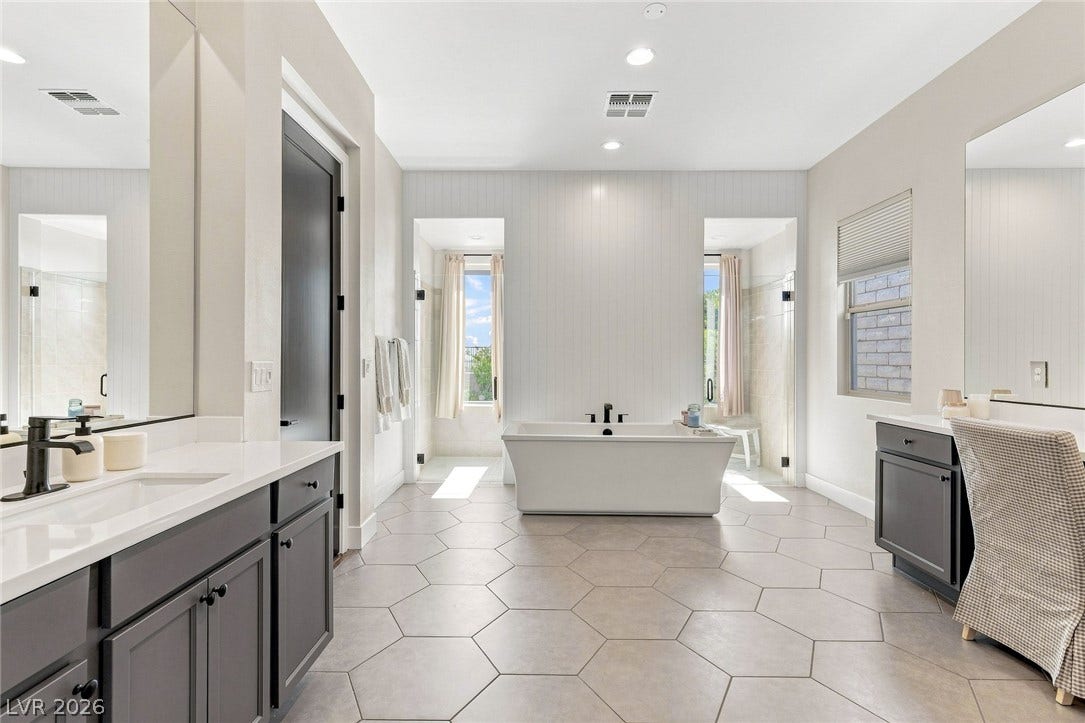 An oversized soaking tub anchor this refined, spa like primary bathroom.