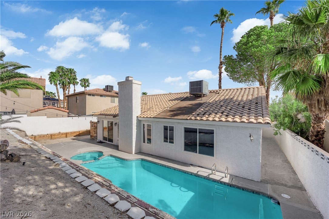 1433 Pathfinder Road, Henderson, NV 89014 An inviting backyard oasis features a shimmering private swimming pool beneath clear desert skies.