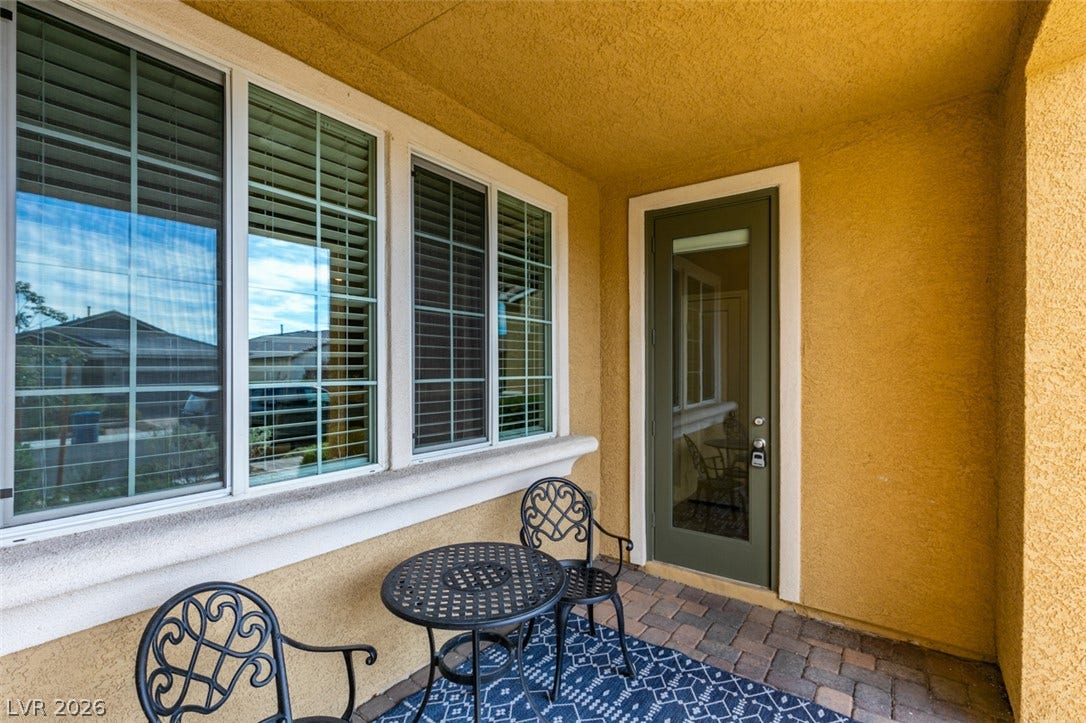 3179 Brynley Avenue, Henderson, NV 89044 A sheltered entryway features paved flooring alongside stucco walls and windows with built-in blinds.