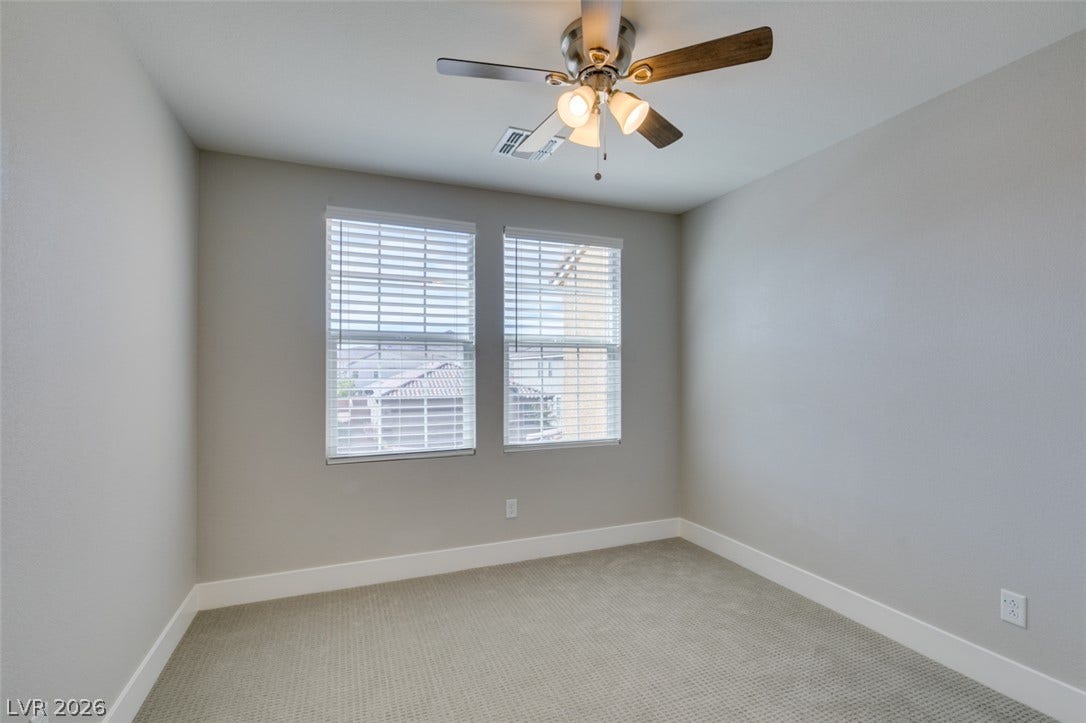 3179 Brynley Avenue, Henderson, NV 89044 Double windows frame neighborhood views, illuminating neutral carpeted flooring and crisp white baseboards.