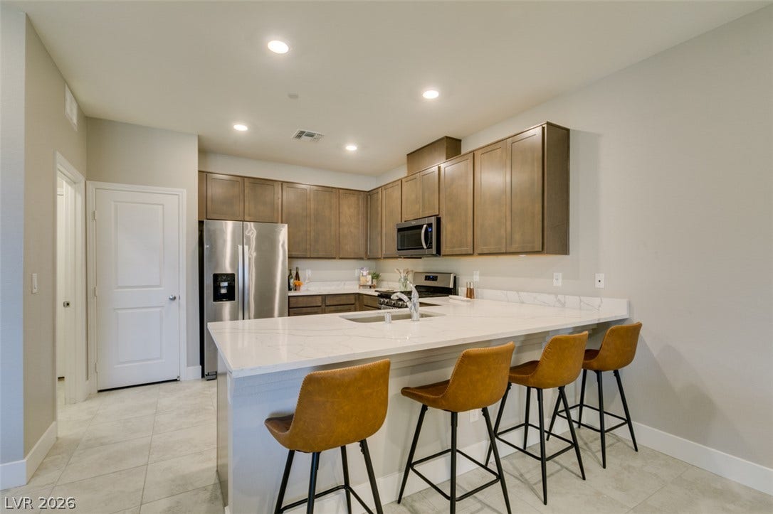 3179 Brynley Avenue, Henderson, NV 89044 Smooth stone countertops and recessed lighting define this functional, open kitchen layout.