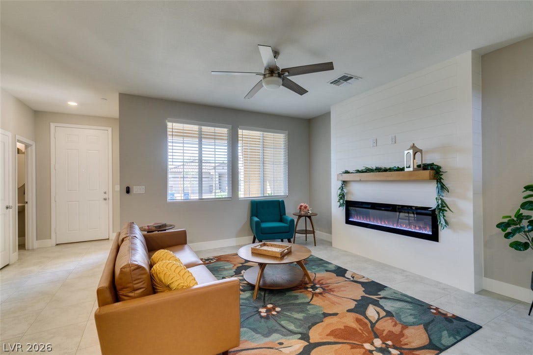 3179 Brynley Avenue, Henderson, NV 89044 An elegant modern fireplace anchors this airy living space with tile flooring.