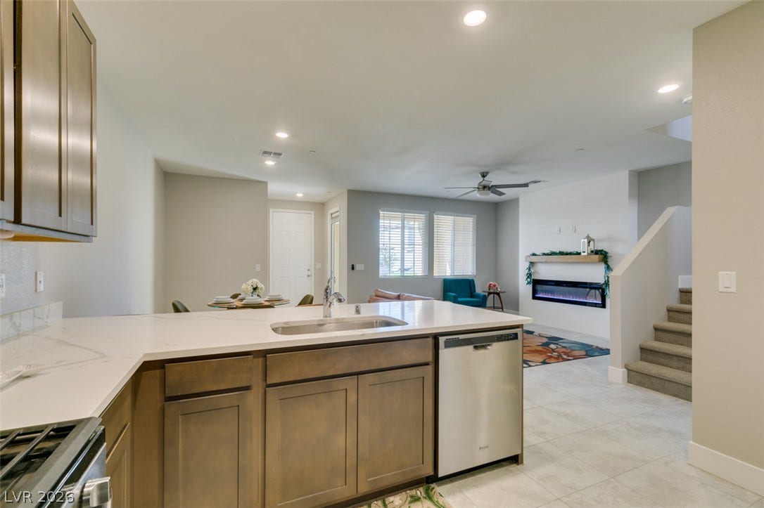 3179 Brynley Avenue, Henderson, NV 89044 Clean tile flooring and stone countertops anchor this welcoming open-concept living space.