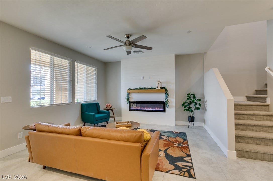 3179 Brynley Avenue, Henderson, NV 89044 Smooth tile flooring, a sleek modern fireplace, and large windows define this welcoming space.