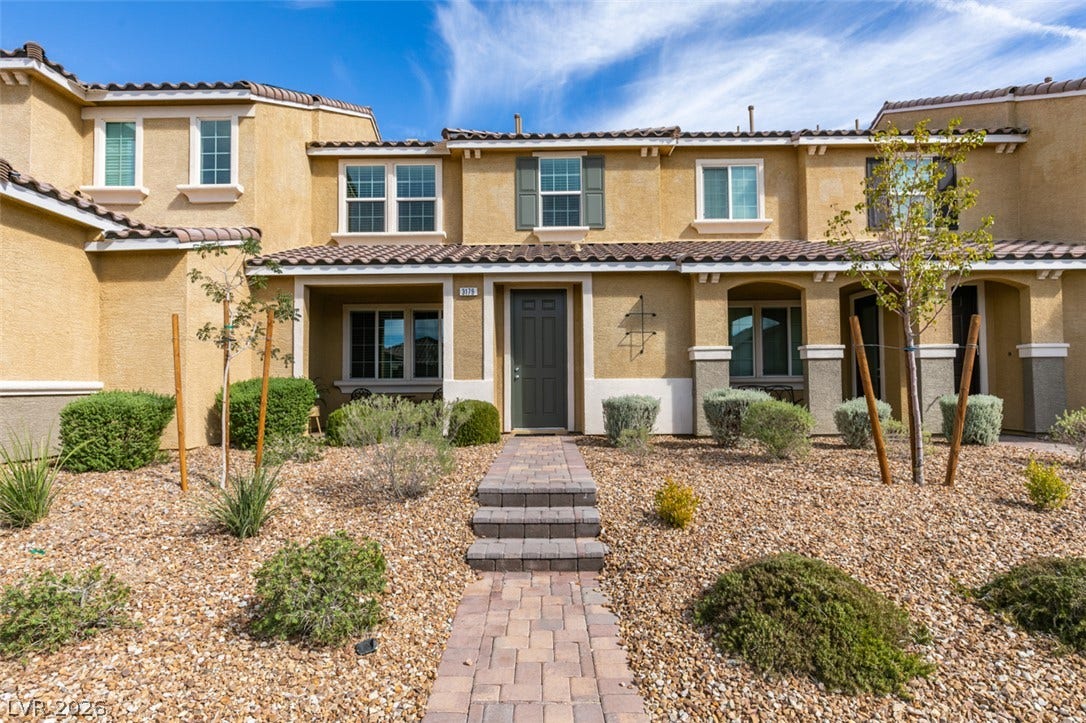 3179 Brynley Avenue, Henderson, NV 89044 A paved path leads directly to the front entrance of this stucco townhouse.