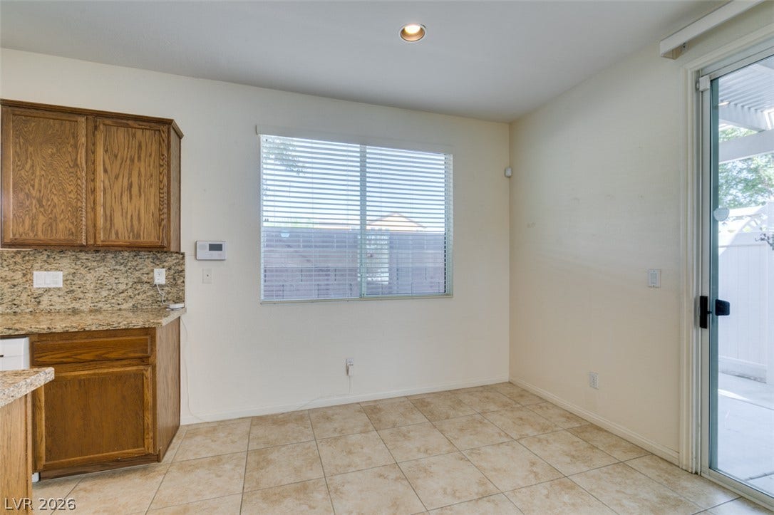 Tiled flooring and natural light from sliding glass doors define this functional dining area.