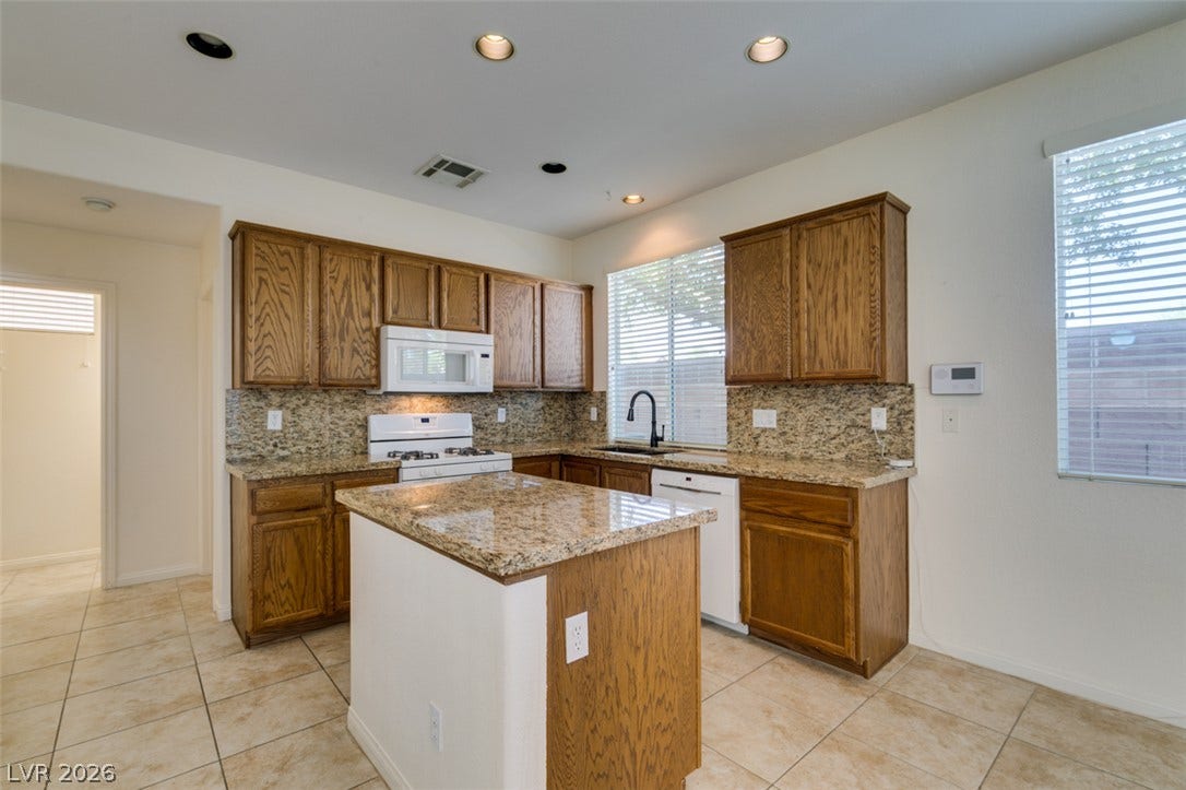 Rich wood cabinetry paired with granite countertops defines this inviting kitchen layout.