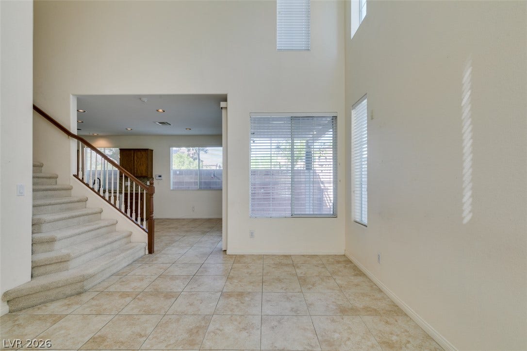 Double-height ceilings and durable tile flooring define this airy entryway highlighted by abundant windows.