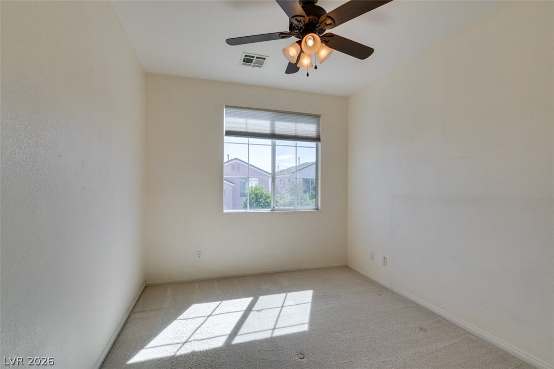 Natural light pours across the carpeted floor from a classic multi-lite window.