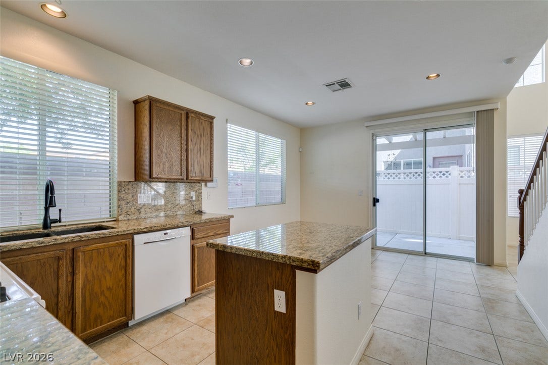Polished stone countertops and clean tile flooring define this functional culinary space.