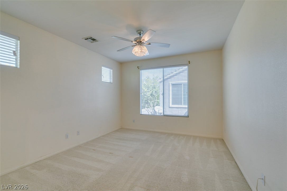 Plush carpeting and abundant natural light create a serene, welcoming atmosphere in this spacious bedroom.