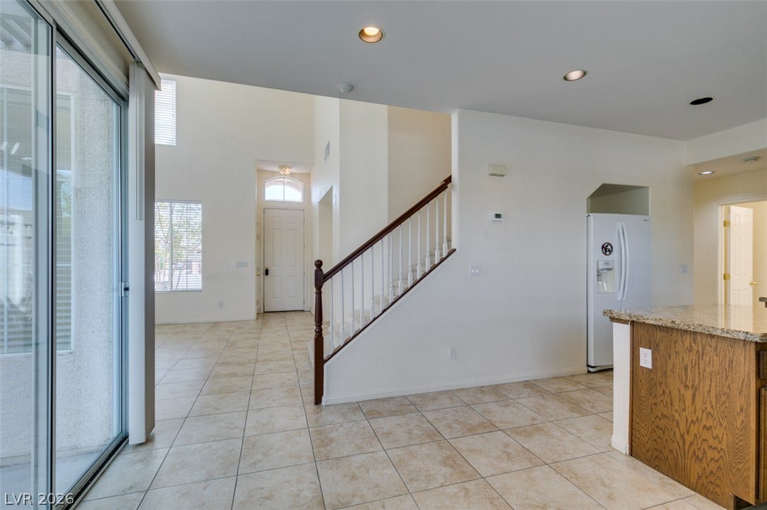 Tiled flooring flows through an open-concept layout connecting the entryway and main living spaces.