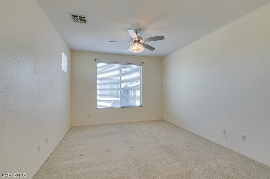 Plush carpeting anchors this versatile room illuminated by natural light from wide windows.