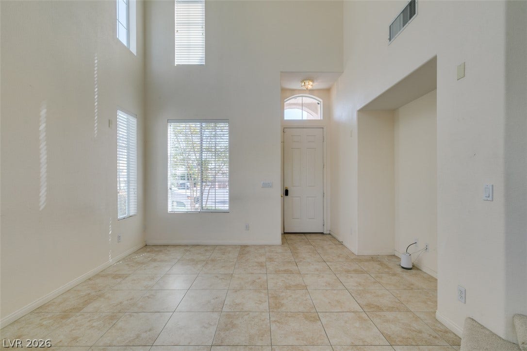 Double-height ceilings and tall windows elevate this tiled entry hall.