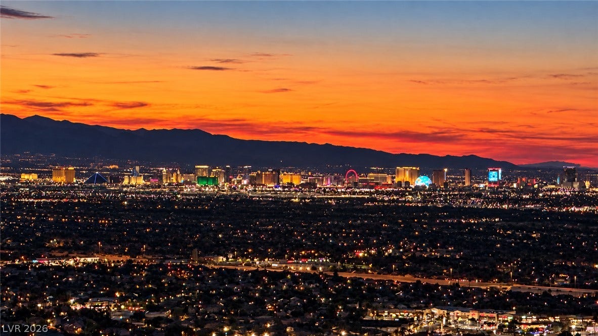 2 Epic View Court, Henderson, NV 89012 Vibrant sunset skies paint a dramatic backdrop over the distant city skyline and mountain range.