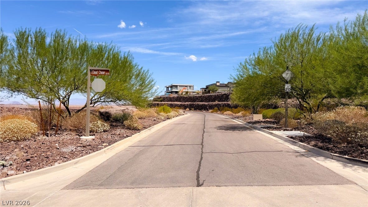 2 Epic View Court, Henderson, NV 89012 Private Paved road which can be gated, wind through a desert community toward hillside homes under clear blue skies.