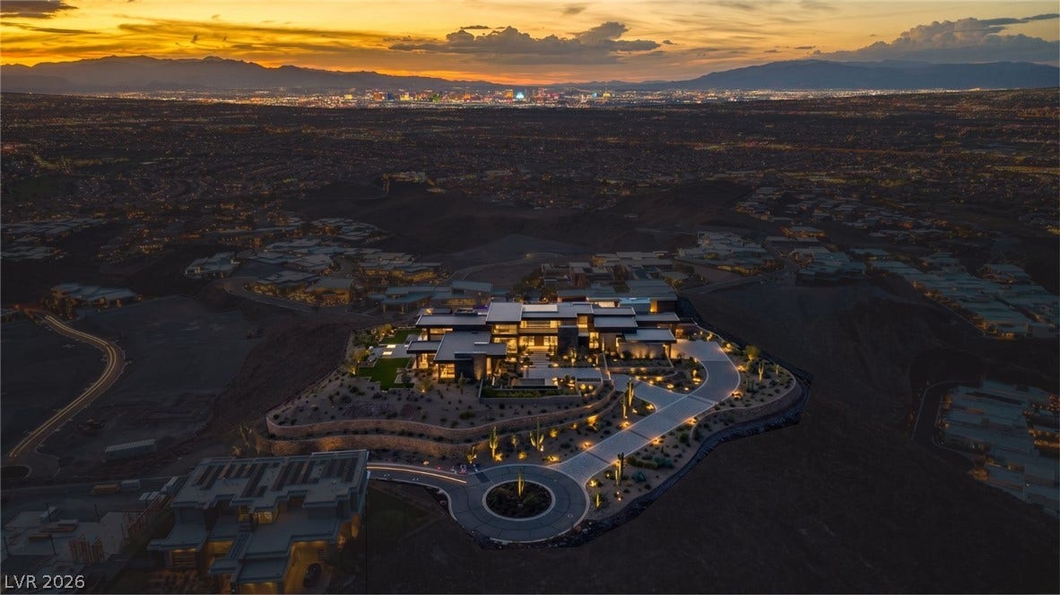 2 Epic View Court, Henderson, NV 89012 An elevated perspective showcases a modern estate nestled on a hillside overlooking distant city lights. Sample Architecture added on the lot.