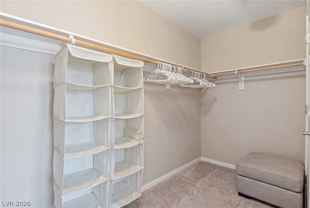 2607 Fading Night Court, Las Vegas, NV 89142 Ample hanging rods and soft carpeting define this functional walk-in closet space.