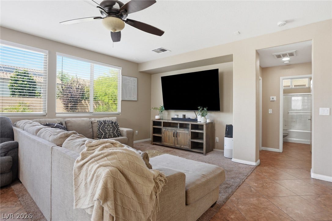 2607 Fading Night Court, Las Vegas, NV 89142 An open living space features soft carpeting alongside tile flooring and generous window views.