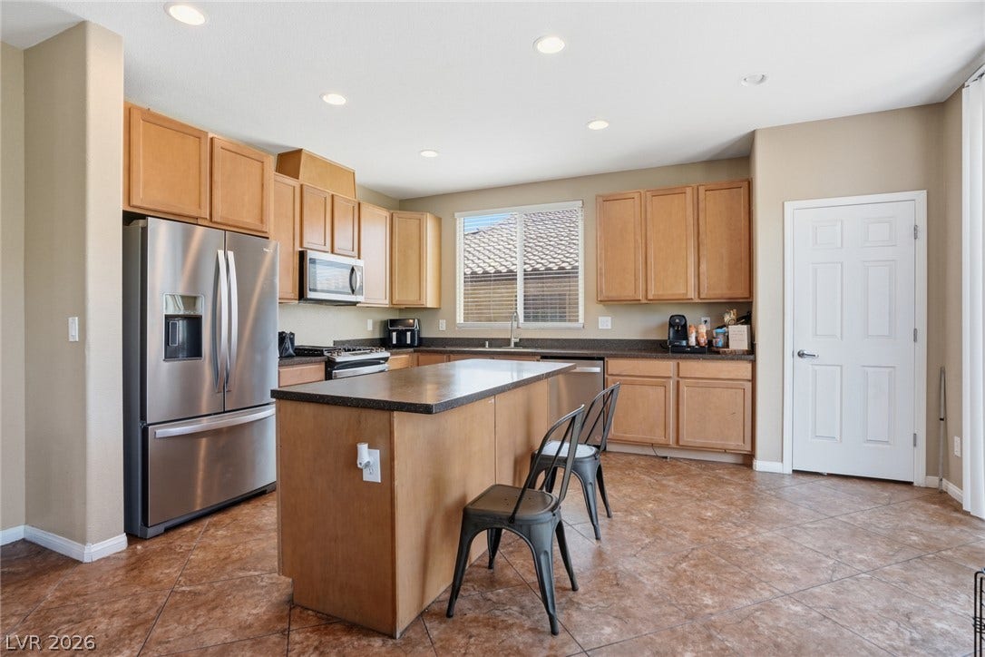 2607 Fading Night Court, Las Vegas, NV 89142 Ample wooden cabinetry and recessed lighting anchor this functional space featuring a central island.