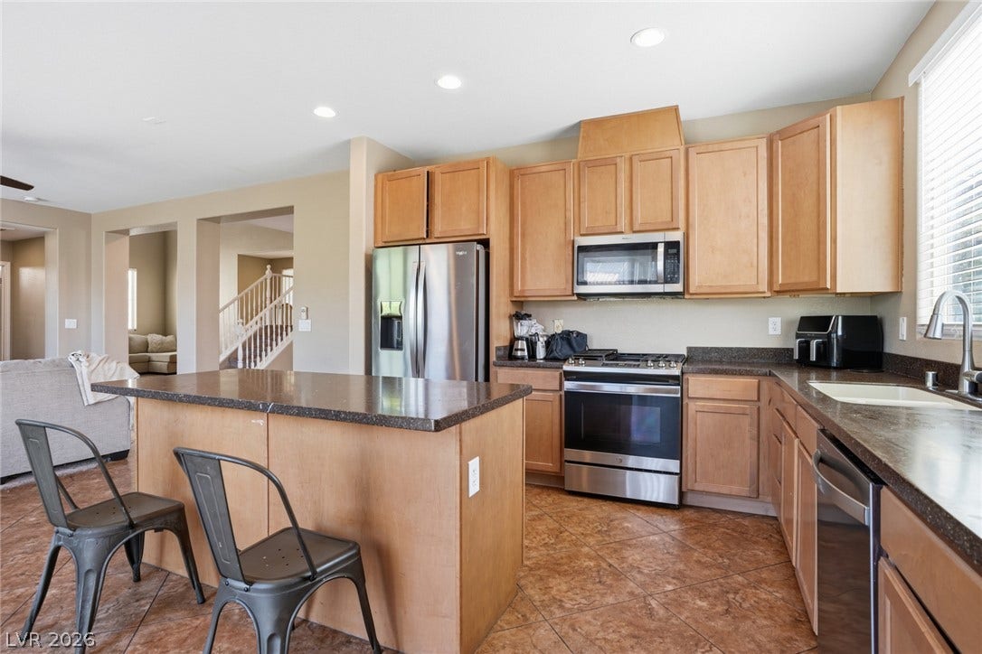 2607 Fading Night Court, Las Vegas, NV 89142 An open kitchen layout features functional workspace cabinetry and classic tile flooring.