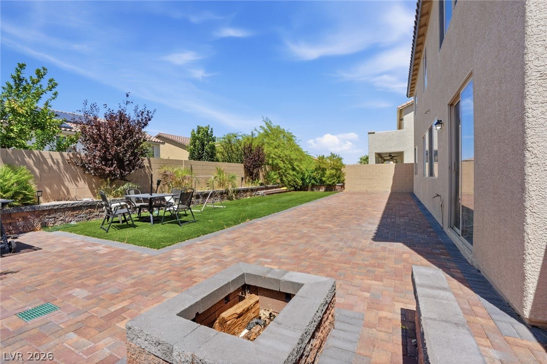 2607 Fading Night Court, Las Vegas, NV 89142 An expansive paver patio centers around a built-in stone fire pit in this low-maintenance backyard.