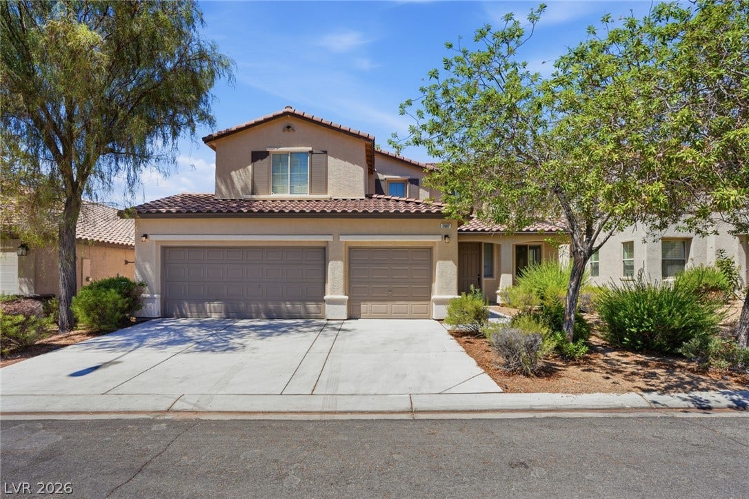 2607 Fading Night Court, Las Vegas, NV 89142 Spanish tile roofing and mature desert landscaping frame the stucco exterior of this multi-level home.