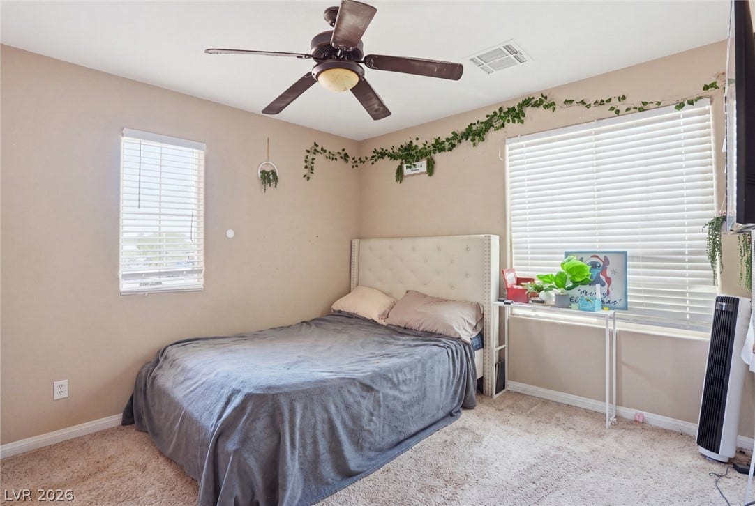 2607 Fading Night Court, Las Vegas, NV 89142 Natural light streams through multiple windows highlighting soft carpeted flooring in this cozy bedroom.