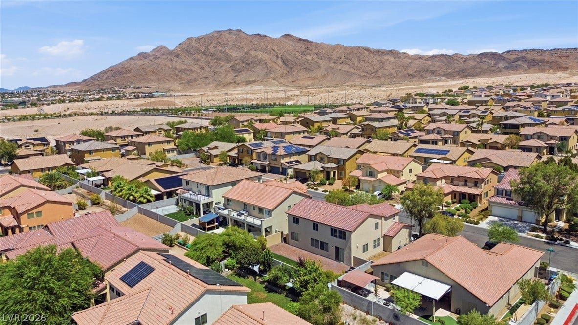 2607 Fading Night Court, Las Vegas, NV 89142 An aerial perspective showcases a vibrant neighborhood nestled against a majestic mountain backdrop.