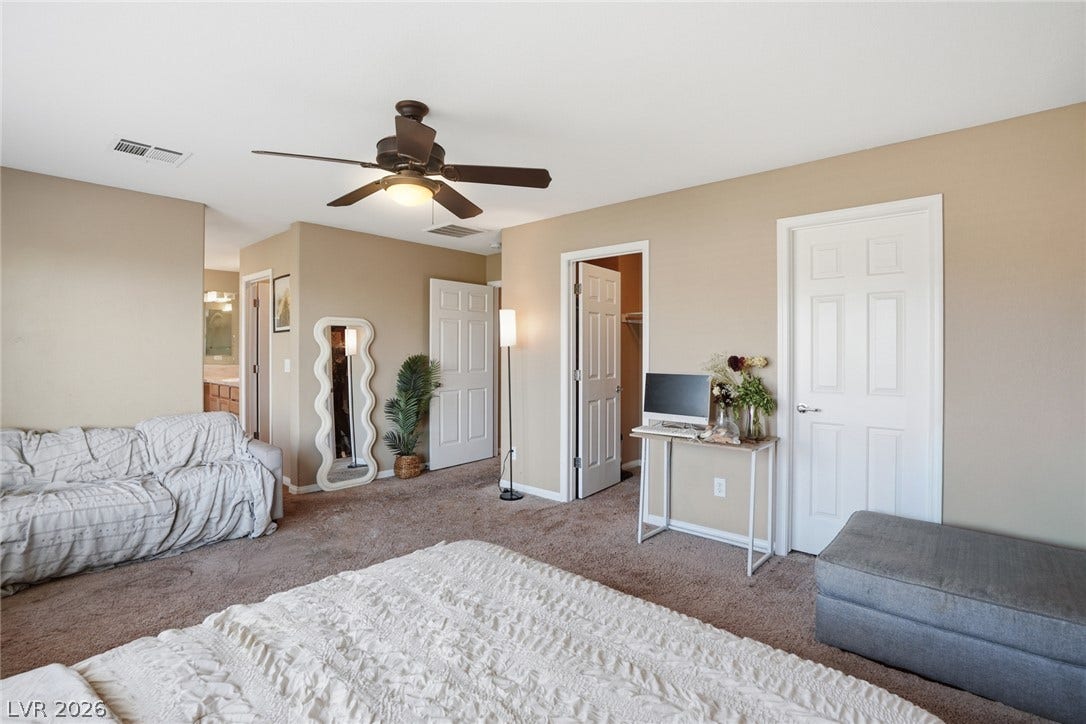 2607 Fading Night Court, Las Vegas, NV 89142 Plush carpeting anchors this spacious primary suite featuring multiple closets and an attached bathroom.