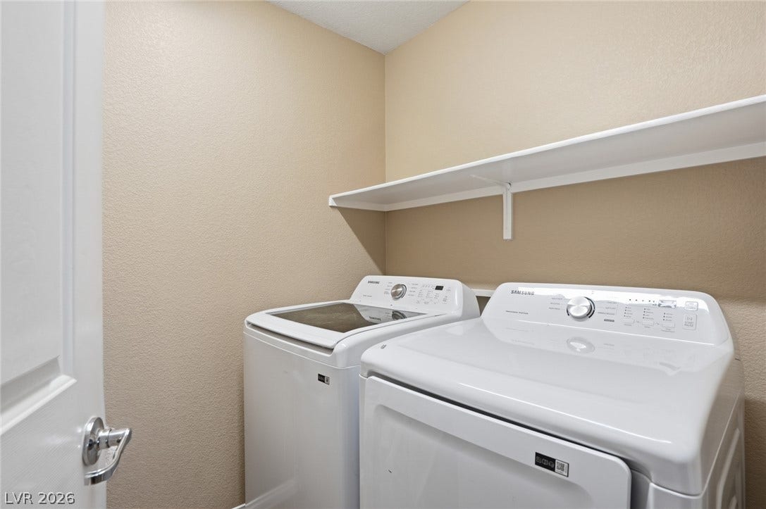 2607 Fading Night Court, Las Vegas, NV 89142 Functional utility space includes overhead storage shelving built above the laundry appliances.