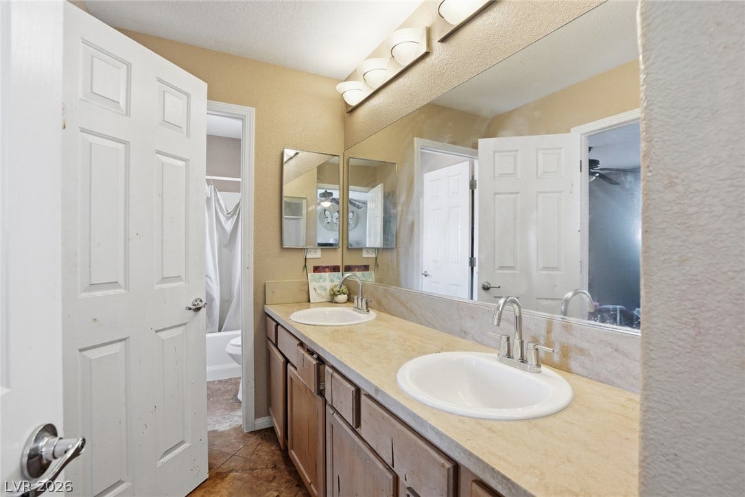 2607 Fading Night Court, Las Vegas, NV 89142 Functional vanity area offers dual sinks and a large mirror above tile flooring.