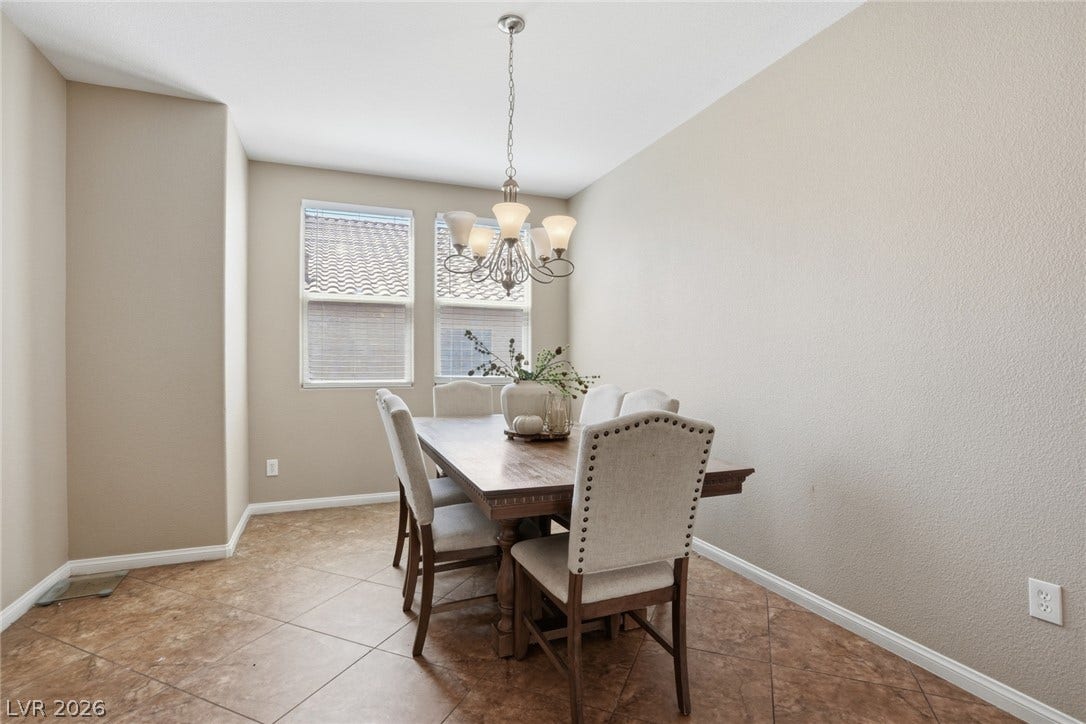 2607 Fading Night Court, Las Vegas, NV 89142 Tiled flooring and natural light from tall windows define this inviting dining room space.