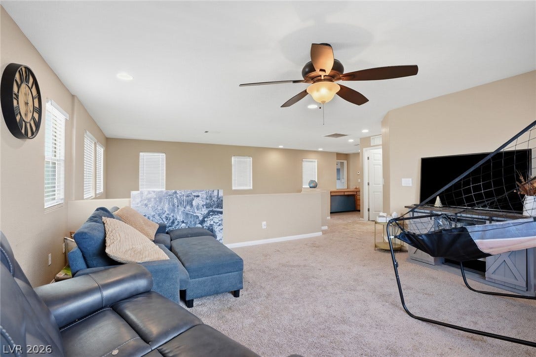 2607 Fading Night Court, Las Vegas, NV 89142 An open upstairs loft area features wall-to-wall carpeting and neutral walls under recessed lighting.