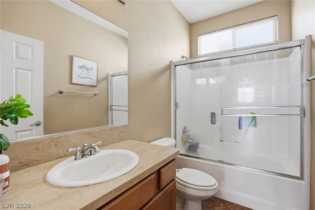 2607 Fading Night Court, Las Vegas, NV 89142 High vaulted ceilings and a sliding glass tub enclosure define this bathroom space.