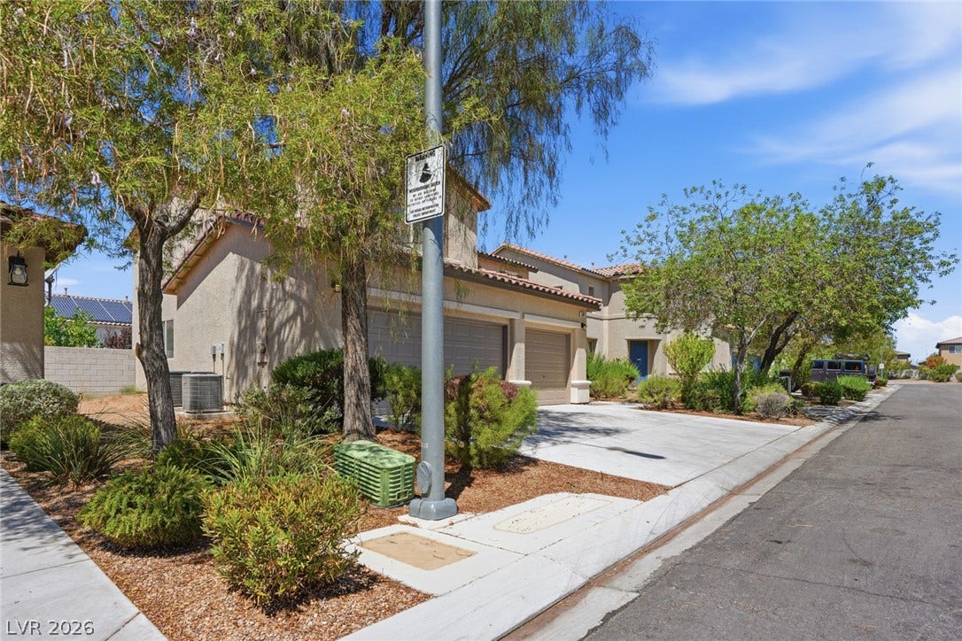 2607 Fading Night Court, Las Vegas, NV 89142 Stucco exteriors and tile roofing define these modern multi-level townhomes set along a paved driveway.