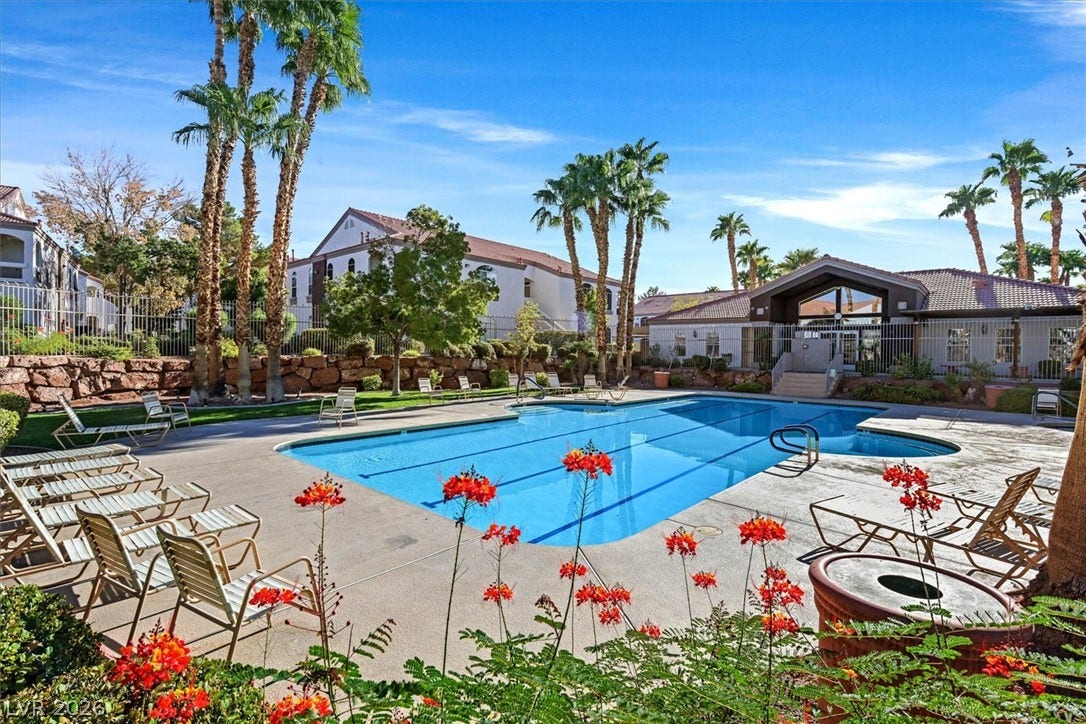 700 Carnegie Street, #2924, Henderson, NV 89052 A sparkling community pool is framed by towering palm trees under a bright blue sky.