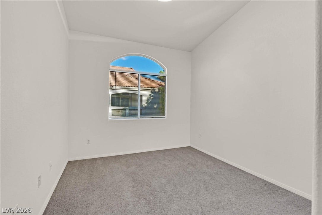 700 Carnegie Street, #2924, Henderson, NV 89052 A classic arched window frames neighborhood views in this carpeted bedroom.