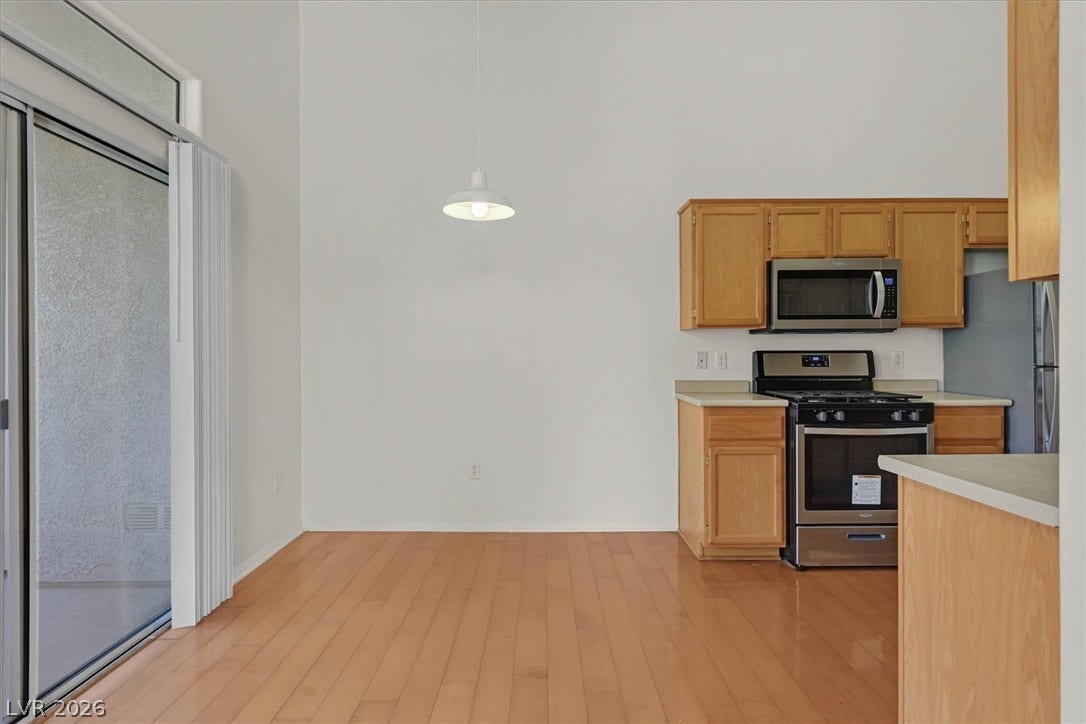 700 Carnegie Street, #2924, Henderson, NV 89052 Warm wood flooring and sliding glass doors define this open dining area and adjacent kitchen.