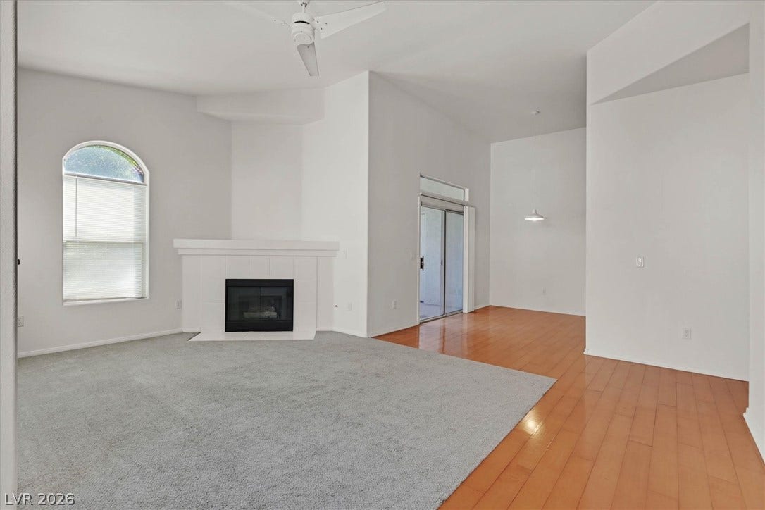 700 Carnegie Street, #2924, Henderson, NV 89052 High ceilings and a wood-mantel fireplace define this open interior with mixed wood and carpet flooring.