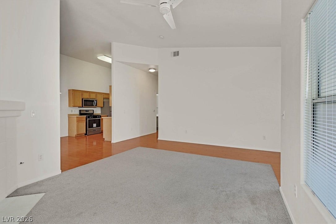 700 Carnegie Street, #2924, Henderson, NV 89052 Plentiful natural light fills a versatile living space featuring carpet flooring and clean white walls.