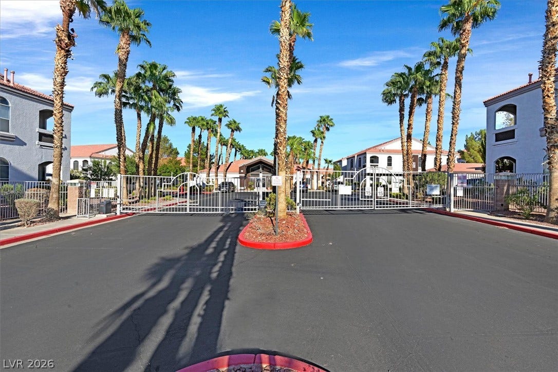 700 Carnegie Street, #2924, Henderson, NV 89052 A gated entrance flanked by mature palm trees leads into a beautifully landscaped residential community.