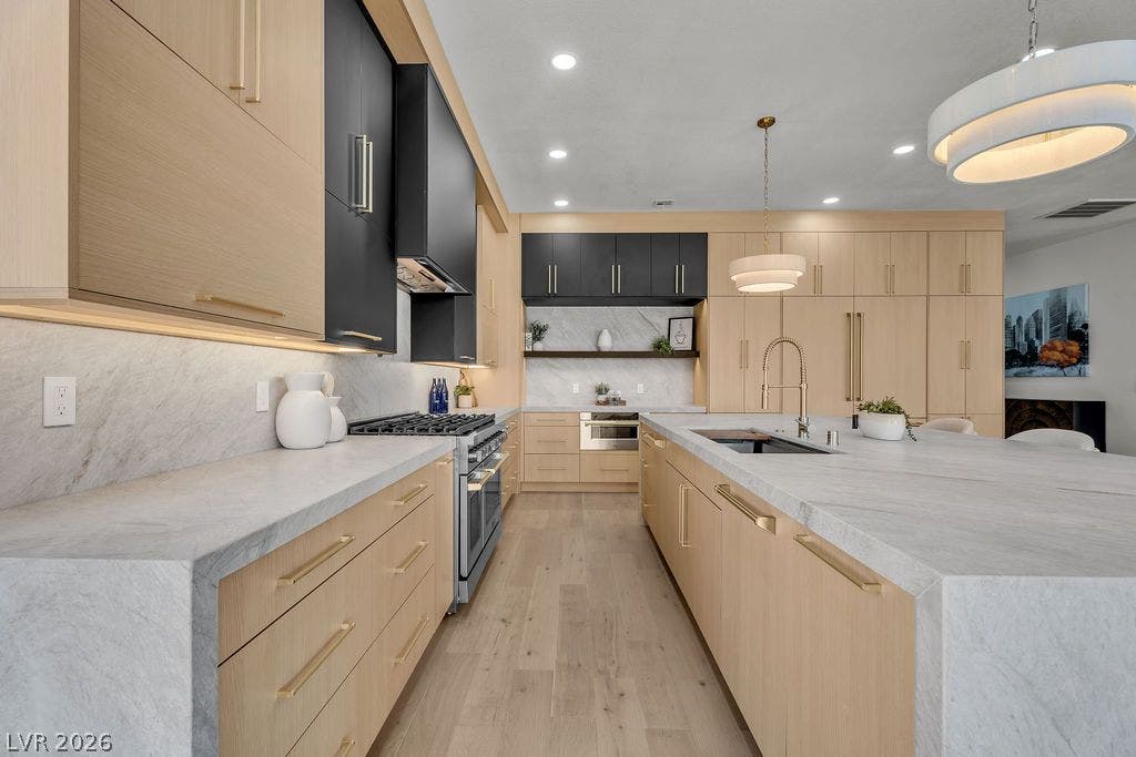 2690 Grassy Spring Place, Las Vegas, NV 89135 Warm wood cabinetry and thick stone countertops define this modern kitchen design.